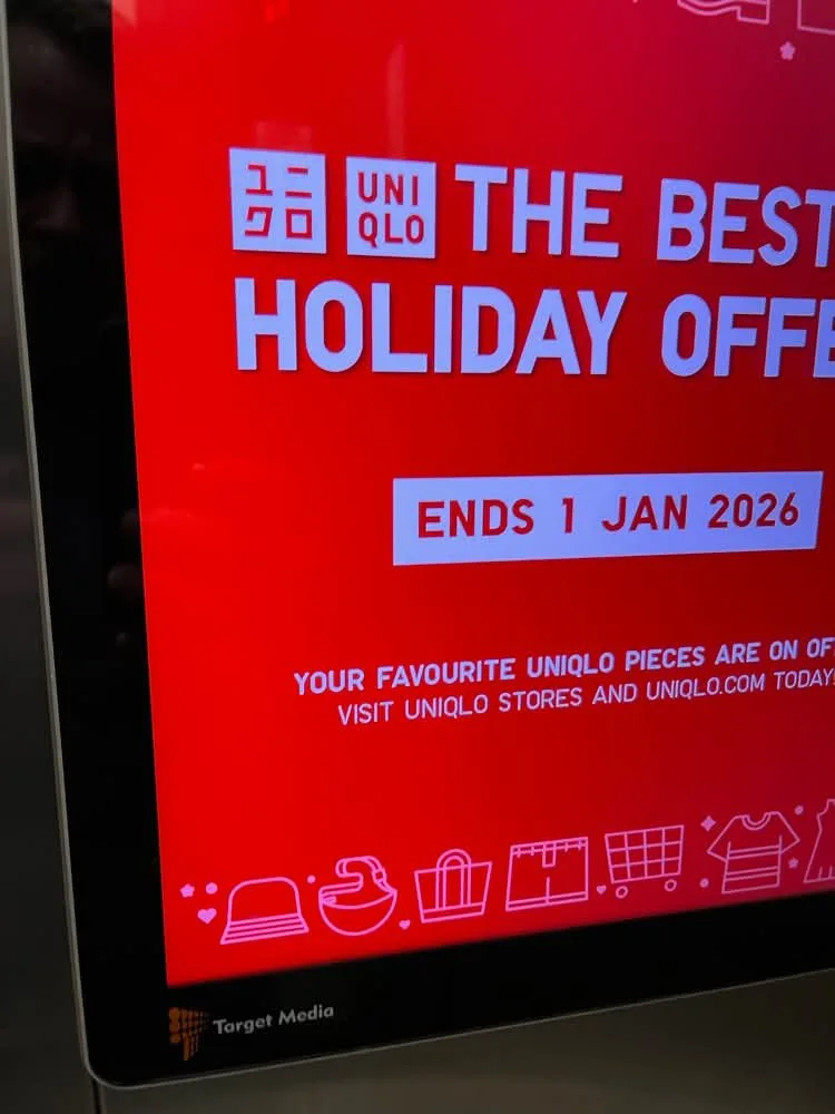 A Target Media screen in a Cyberjaya elevator advertising holiday offers.